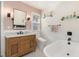 Elegant bathroom with a wooden vanity, freestanding tub, and patterned tile floor at 114 Mcgregor St, Punta Gorda, FL 33950