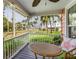 Charming porch with table and chairs overlooking a peaceful scene with palm trees and water views at 114 Mcgregor St, Punta Gorda, FL 33950