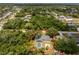 Birds-eye view of the property including screened pool and proximity to mature trees, surrounded by community at 1173 Belmar Ave, Port Charlotte, FL 33948