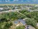 Expansive aerial view of a home featuring a screened-in pool, lush landscaping, and a glimpse of the surrounding neighborhood at 1173 Belmar Ave, Port Charlotte, FL 33948