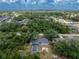 Wide aerial shot showing the home in a wooded neighborhood and screened pool from an elevated vantage point at 1173 Belmar Ave, Port Charlotte, FL 33948