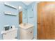 Light blue bathroom with a white vanity and wood finished door at 1173 Belmar Ave, Port Charlotte, FL 33948