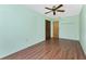 Simple bedroom with wood floors, a ceiling fan and light green walls at 1173 Belmar Ave, Port Charlotte, FL 33948