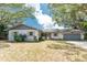 Charming home exterior with a gray roof, stone accents, a well-manicured lawn, and a two-car garage at 1173 Belmar Ave, Port Charlotte, FL 33948