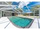 A screened-in swimming pool with steps and railing for accessibility and a view of the exterior of the home at 1173 Belmar Ave, Port Charlotte, FL 33948