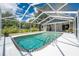 A screened-in swimming pool with steps and railing for accessibility and a view of the exterior of the home at 1173 Belmar Ave, Port Charlotte, FL 33948