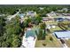 Aerial view of a home with a green roof, complemented by lush greenery and neighboring houses in a quiet community at 1381 Fargo St, Port Charlotte, FL 33952