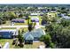 Bird's-eye view of home with green roof, mature trees, and lush landscaping in a quiet neighborhood setting at 1381 Fargo St, Port Charlotte, FL 33952