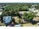Overhead shot of the property showcases the layout, trees, fenced yard, and proximity to surrounding neighborhood streets at 1381 Fargo St, Port Charlotte, FL 33952