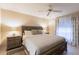 Bedroom with tile flooring, ceiling fan, and large bed with soft lighting from bedside lamps at 1381 Fargo St, Port Charlotte, FL 33952