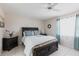 Comfortable bedroom featuring tile floor, ceiling fan, dark wood furnishings, and soft blue accents at 1381 Fargo St, Port Charlotte, FL 33952
