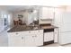 Bright kitchen area with granite counters, white cabinets, a dishwasher, and a view to the living room at 1381 Fargo St, Port Charlotte, FL 33952