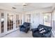Bright sunroom features tile flooring, ceiling fan, and comfortable seating with easy access to outdoors through french doors at 1381 Fargo St, Port Charlotte, FL 33952