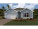 Charming single-story home with a two-car garage, manicured lawn, and beautiful landscaping at 15264 Buswell Ave, Port Charlotte, FL 33953