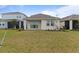 Backyard featuring green grass and a view of the covered patio with sliding glass doors at 15975 Mulrion Blvd, Punta Gorda, FL 33982