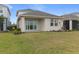 Backyard featuring green grass and a view of the covered patio with sliding glass doors at 15975 Mulrion Blvd, Punta Gorda, FL 33982