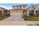Two-story home featuring a neutral color scheme, attached garage and a driveway made of paving stones at 15975 Mulrion Blvd, Punta Gorda, FL 33982