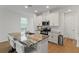 Modern kitchen featuring an island with granite countertops, stainless steel appliances, and white cabinets at 15975 Mulrion Blvd, Punta Gorda, FL 33982