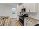Bright kitchen featuring an island with granite countertops, stainless steel appliances, and white cabinets at 15975 Mulrion Blvd, Punta Gorda, FL 33982