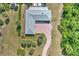 Aerial view of a home with a gray roof, brick driveway, patio, and lush surrounding landscaping at 17506 Cape Horn Blvd, Punta Gorda, FL 33955