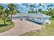 Charming single-story home with paver driveway and lush landscaping, including tall palm trees at 17506 Cape Horn Blvd, Punta Gorda, FL 33955