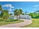 Lovely one-story home featuring a paver driveway and well-maintained green lawn with palm trees at 17506 Cape Horn Blvd, Punta Gorda, FL 33955