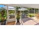 Cozy screened patio featuring wicker furniture, potted plants, and a peaceful outdoor setting at 17506 Cape Horn Blvd, Punta Gorda, FL 33955