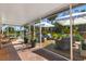 Enclosed patio featuring brick flooring, plants, and wicker furniture underneath an awning at 17506 Cape Horn Blvd, Punta Gorda, FL 33955