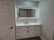 Bathroom features a sleek vanity with ample storage and an illuminated mirror at 21215 Cottonwood Ave, Port Charlotte, FL 33952