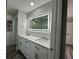Modern bathroom featuring double sinks with a lighted mirror and white cabinetry at 21215 Cottonwood Ave, Port Charlotte, FL 33952