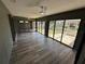 Bright Florida room with gray wood-look floors, multiple sliding glass doors, and ceiling fans at 21215 Cottonwood Ave, Port Charlotte, FL 33952