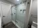 The bathroom features a modern glass shower with gray pebble tile and white tiled walls at 21215 Cottonwood Ave, Port Charlotte, FL 33952