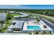 Aerial view of community pool area, featuring lounge chairs, a cabana, and lush landscaping at 25225 Rampart Blvd # 1607, Punta Gorda, FL 33983