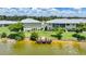 A view of the lake with a wooden dock and chairs behind a condo building at 25225 Rampart Blvd # 1607, Punta Gorda, FL 33983