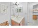 This bathroom features a single sink vanity, mirrored medicine cabinet, and a view into the kitchen at 25225 Rampart Blvd # 1607, Punta Gorda, FL 33983