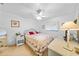 Inviting bedroom with a ceiling fan, a bed adorned with floral patterns, and wicker furniture at 25225 Rampart Blvd # 1607, Punta Gorda, FL 33983