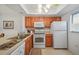 Kitchen featuring white appliances, wood cabinets and neutral countertop at 25225 Rampart Blvd # 1607, Punta Gorda, FL 33983