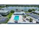 Aerial view of a community pool with a clubhouse, manicured landscaping, and lounge seating at 25225 Rampart Blvd # 1607, Punta Gorda, FL 33983