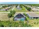 Aerial view of a home featuring a screened pool, solar panels, and neighborhood surroundings at 2636 Mauritania Rd, Punta Gorda, FL 33983