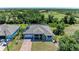 Aerial view of a home featuring a long driveway, screened pool, and lush green surroundings at 2636 Mauritania Rd, Punta Gorda, FL 33983