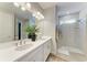 This modern bathroom features double sinks, white cabinets, and a glass shower, with modern fixtures and accents at 2636 Mauritania Rd, Punta Gorda, FL 33983