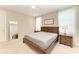 This bedroom offers a natural wood bed frame with a plush mattress and ample natural light from the windows at 2636 Mauritania Rd, Punta Gorda, FL 33983