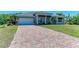 Home with a brick driveway, two-car garage, green lawn and well-maintained landscaping at 2636 Mauritania Rd, Punta Gorda, FL 33983