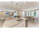 Bright kitchen with granite island, pendant lighting, stainless sink, and open view to the living and dining areas at 2636 Mauritania Rd, Punta Gorda, FL 33983