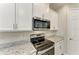 Close-up of modern kitchen featuring stainless steel appliances, granite countertops, and stylish backsplash at 2636 Mauritania Rd, Punta Gorda, FL 33983