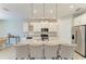 Close up view of the kitchen island with granite countertops and a stainless steel refrigerator at 2636 Mauritania Rd, Punta Gorda, FL 33983