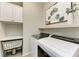 Organized laundry area with modern washer and dryer, storage cabinets, and stylish decor at 2636 Mauritania Rd, Punta Gorda, FL 33983