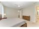 Bright main bedroom featuring wood furniture, neutral walls, ceiling fan, and ensuite bathroom at 2636 Mauritania Rd, Punta Gorda, FL 33983