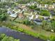 An aerial view of a canal community shows waterfront homes among mature tree landscaping at 2776 Tusket Ave, North Port, FL 34286