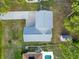 An aerial view of a home shows the driveway, roof, adjacent pool, and shed in the backyard at 2776 Tusket Ave, North Port, FL 34286
